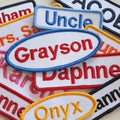 Collection of block font, embroidered name patches with various names on a textured surface.
